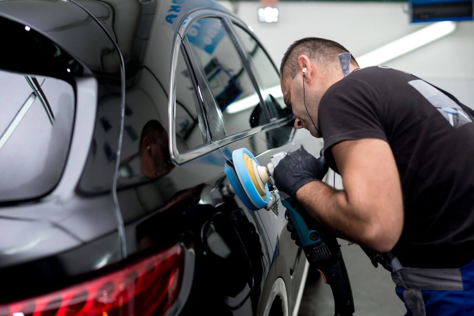 Car detailing expert from Сaledon waxing a car.